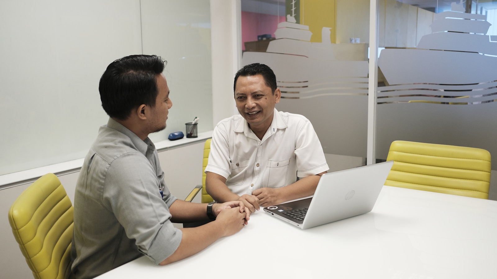 Dua operator bisnis Indonesia meninjau laptop saat mengecek akses akun, vendor, dan jalur digital sebelum menjalankan campaign.