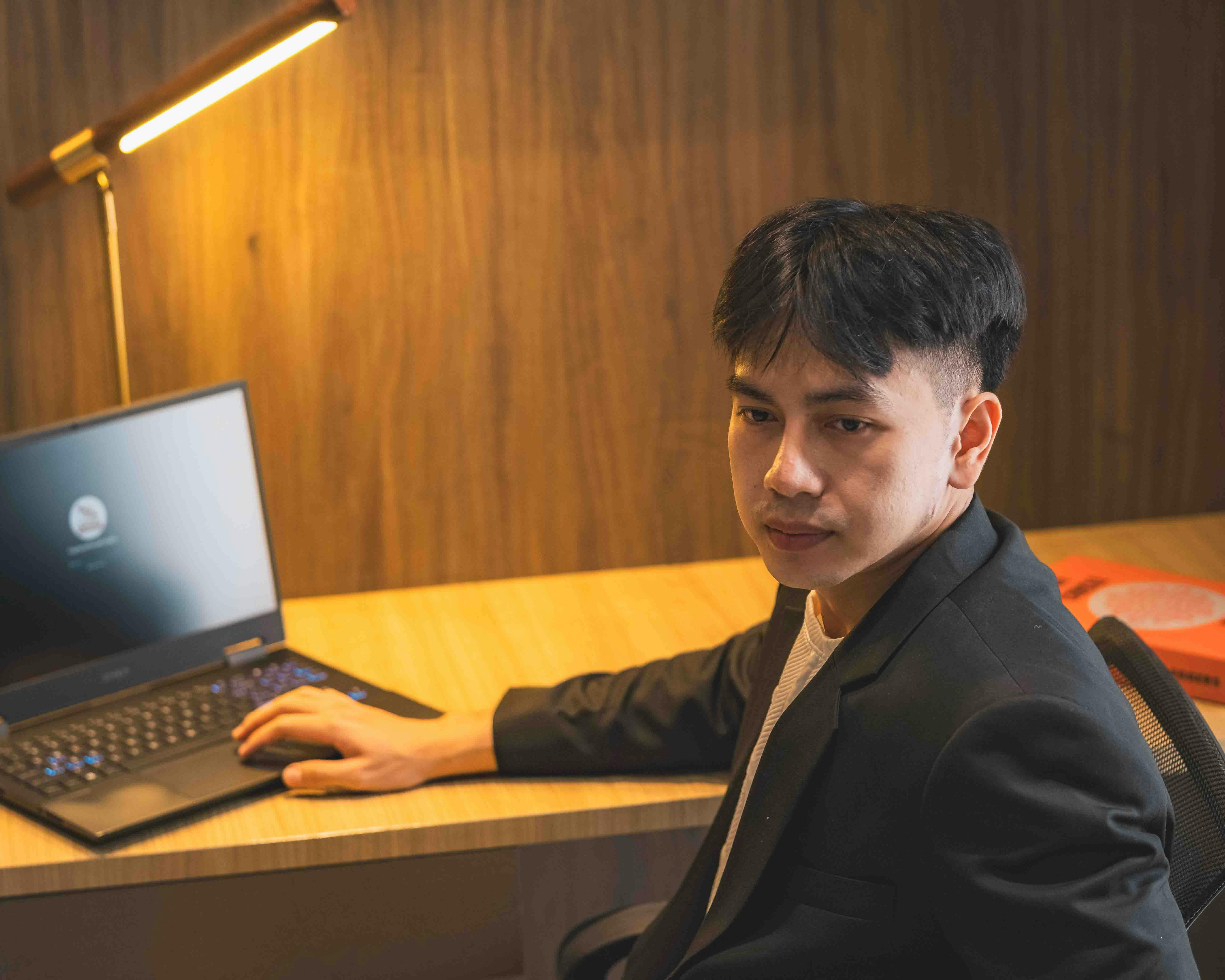 Pemilik bisnis Indonesia meninjau visual website di laptop untuk memilih foto yang terasa kredibel