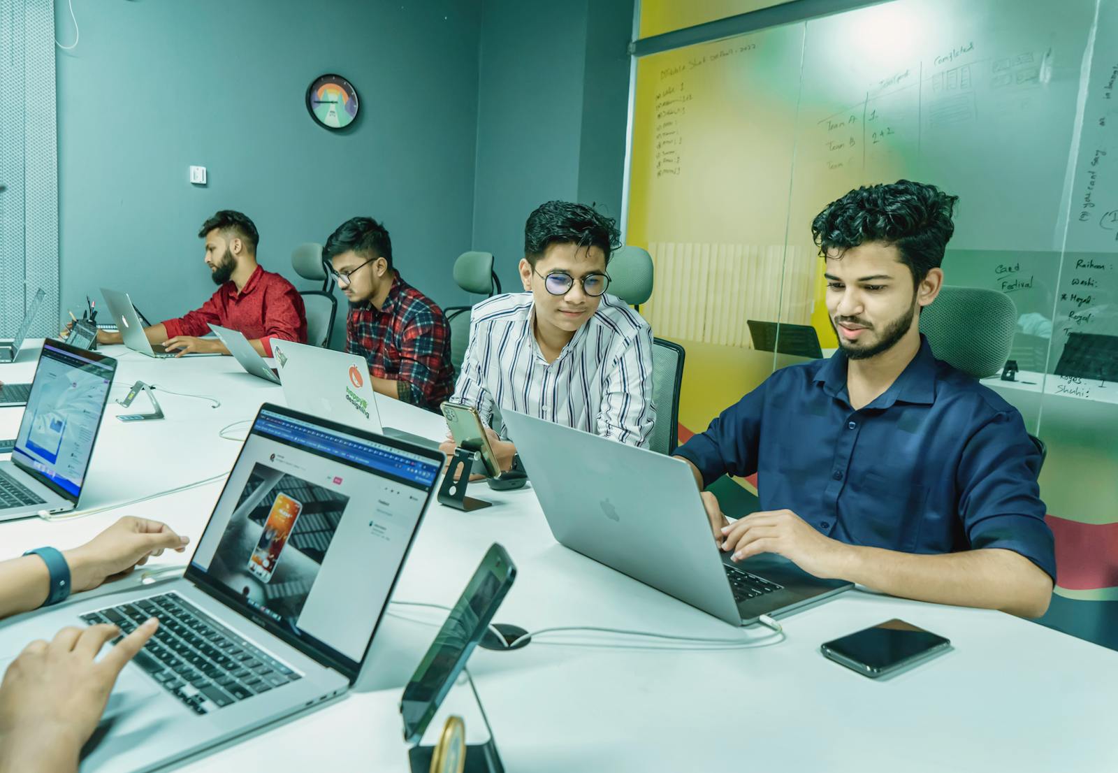 Tim digital sedang meninjau website di beberapa laptop sebagai bagian dari audit SEO teknis.